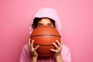 flicka innehav basketboll boll på rosa bakgrund foto