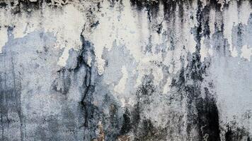 gammal cement vägg skala exteriör textur bakgrund med vit måla peeling låg kvalitet, knäckt vägg foto