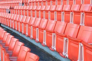 tömma orange säten på stadion, rader av sittplats på en fotboll stadion foto