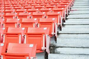 tömma orange säten på stadion, rader av sittplats på en fotboll stadion foto