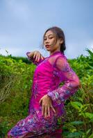 ett asiatisk kvinna Framställ mycket sexig bland de te plantager medan bär en rosa klänning foto