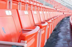 tömma orange säten på stadion, rader av sittplats på en fotboll stadion foto