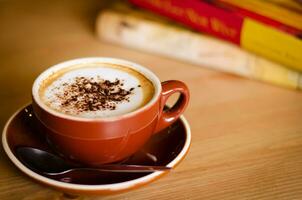 kopp av cappuccino kaffe och böcker i mysigt Kafé foto