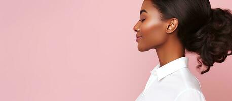 stänga upp porträtt av ett elegant afrikansk amerikan kvinna i en klassisk vit skjorta Framställ i en studio på en rosa bakgrund med ett tömma Plats för text foto