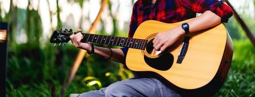 person som spelar gitarr utanför foto