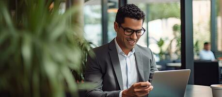mogna affärsman använder sig av mobil app och bärbar dator i kontor leende foto