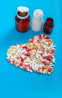medicinsk piller och tabletter spill ut av en läkemedel flaska på blå bakgrund foto