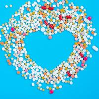 många piller i de form av en hjärta flerfärgad på en blå bakgrund foto