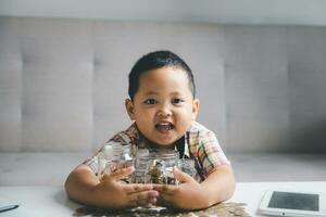 preschooler barn inlärning till Beräkna personlig budget, klara av finansiera, spelar investering, bokföring. fokuserade skola unge sparande pengar för inköp, sätta kontanter i rosa nasse Bank på Hem. foto