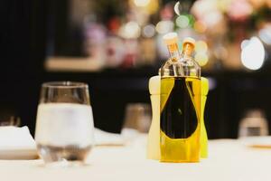 en glas flaska med oliv olja och balsamisk vinäger på middag tabell. foto