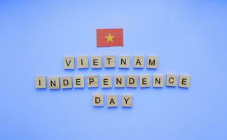 september 2, vietnam oberoende dag, vietnam flagga, minimalistisk baner med trä- brev på en blå bakgrund foto