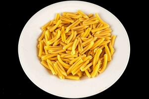 en vit tallrik fylld med gul pasta foto