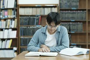 universitet studenter läsning böcker i bibliotek för forskning. foto