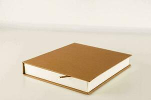 en bok med en brun omslag Sammanträde på en tabell foto