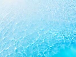 textur av vatten krusning reflektioner på ljus blå botten. yta av blå simning slå samman. abstrakt vatten bakgrund med kopia Plats för några ändamål. topp se. ai genererad foto