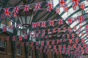 nationell flaggor hängande i rad från tak inuti kloster trädgård i London foto