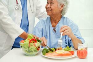 asiatisk dietist innehav friska mat för patient i sjukhus, näring och vitamin. foto