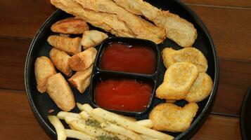 franska pommes frites, nuggets och utsökt friterad otak otak eras med kryddad sås foto