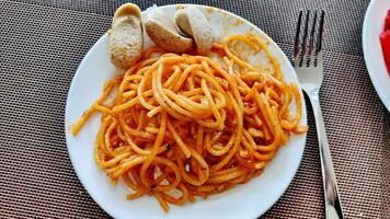 utsökt spaghetti bolognese eras på en vit tallrik foto