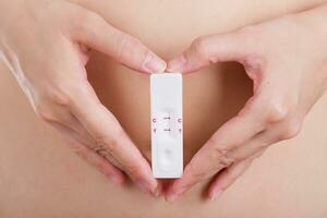 stänga upp graviditet testa med kärlek kvinnor känsla lycka. foto