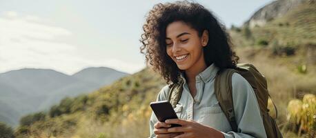 leende latin kvinna resande använder sig av telefon app till kontrollera digital kamera utomhus teknologi begrepp foto