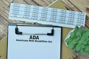 begrepp av ada - amerikaner med funktionshinder spela teater skriva på pappersarbete isolerat på trä- tabell. foto
