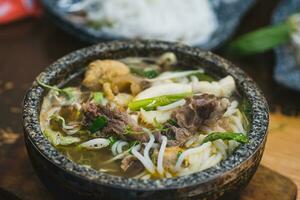 bulle bo nyans, bulle bo, vietnamese nötkött nudel soppa kryddad i sten skål foto