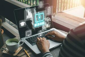 webinar e-learning Träning företag internet teknologi begrepp. person hand använder sig av bärbar dator dator och smart telefon med vr skärm webinar ikon på kontor skrivbord. foto