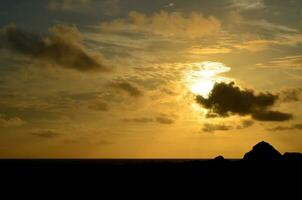 fantastisk soluppgång längs de kust med massor av moln foto