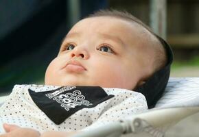 stänga upp skott av söt asiatisk pakistansk 4 månader gammal bebis pojke, vem är njuter på Hem trädgård på luton stad av England Storbritannien. bild var fångad på juli 23:e, 2023 foto
