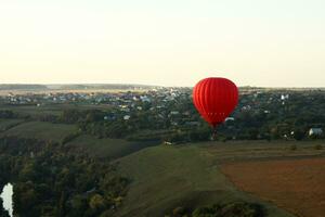 varm luft ballong över grön fält foto