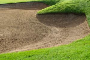 golf kurs sand grop bunkrar, grön gräs omgivande de skön sand hål är ett av de mest utmanande hinder för golfare och lägger till till de skönhet av de golf kurs. foto