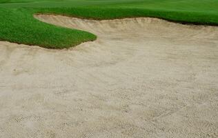 golf kurs sand grop bunkrar, grön gräs omgivande de skön sand hål är ett av de mest utmanande hinder för golfare och lägger till till de skönhet av de golf kurs. foto