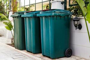 stor grön wheelie bin på offentlig parkera. foto