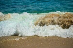 små vågor skapande skum på de strand med vit sand, varm dag och lugna hav, mahe Seychellerna foto