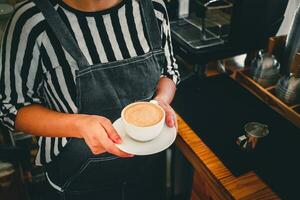 en kopp av kaffe cappuccino meny redo till tjäna i hand kvinna Barista i de kaffe affär foto