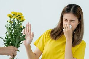 pollen allergier, asiatisk ung kvinna nysning i en näsduk eller blåser i en torka, allergisk till vild vår blommor eller blommar under vår. allergisk reaktion, respiratorisk systemet problem foto