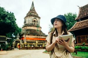 asiatisk resande kvinna med läsplatta på ok moli tempel i chiang mai provins, thailand foto