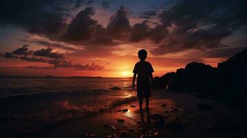 pojke s översikt i solnedgång på de hav. silhuett begrepp foto