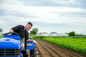 kherson oblast, ukraina - Maj 29, 2021 ett äldre jordbrukare enheter en traktor på en odla. fräsning jord, lossna jord innan skärande rader. förberedelse av landa för framtida plantering ny beskära. foto