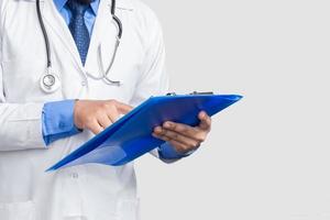 läkare i laboratorierock som håller och läser patientmapp eller medicinska anteckningar som ser, isolerad på vit bakgrund