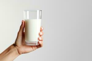 hand innehav en glas av färsk mjölk isolerat på grå bakgrund med kopia Plats. ai genererad foto