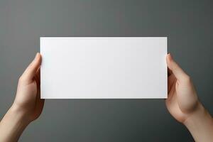 en mänsklig hand innehav en tom ark av vit papper eller kort isolerat på grå bakgrund. ai genererad foto