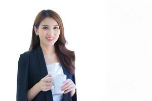 professionell ung asiatisk kvinna kontor arbetstagare stående förbi innehav en kaffe kopp medan isolerat på vit bakgrund i de arbetsplats foto