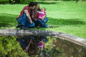 ung föräldrar har roligt utomhus med deras sex månader gammal bebis flicka. lycka begrepp. familj begrepp foto