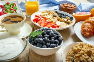 friska frukost eras med tallrik av yoghurt mysli blåbär jordgubbar och banan. foto