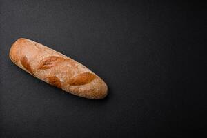 franska baguette bröd på en mörk texturerad betong bakgrund foto