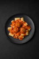 utsökt färsk köttbullar och pasta i tomat sås med salt, kryddor och örter foto