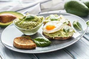 rostat bröd bröd med guacamole spridning och ägg. foto