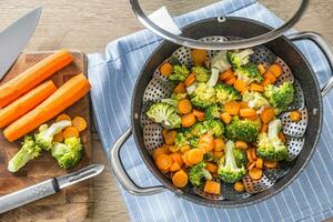 ångad blandad vegetabiliska i svart pott. friska vegetabiliska begrepp foto